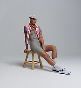 Amber checkered heritage cycling cap on seated cyclist in matching retro kit — breathable vintage-style bike cap for road rides and cafe stops