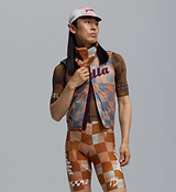 Heritage Checkers amber retro road cycling cap close-up on a rider with matching checkered kit and neck gaiter — vintage-style cycling apparel and cafe-stop essential for riders en route