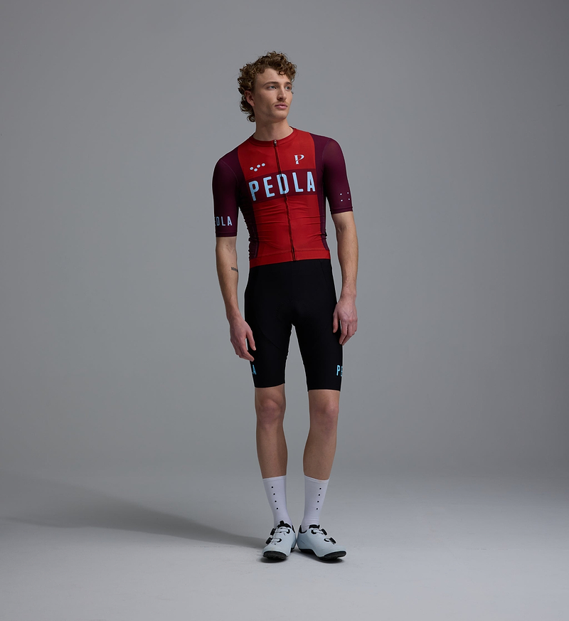 Heritage men's Classic road cycling jersey, traditional Fox Red front view on model — slim-fit short-sleeve PEDLA/LunaLUXE, breathable SPF50 moisture-wicking four-way stretch fabric, ventilation panels, low-cut collar and silicone hem gripper
