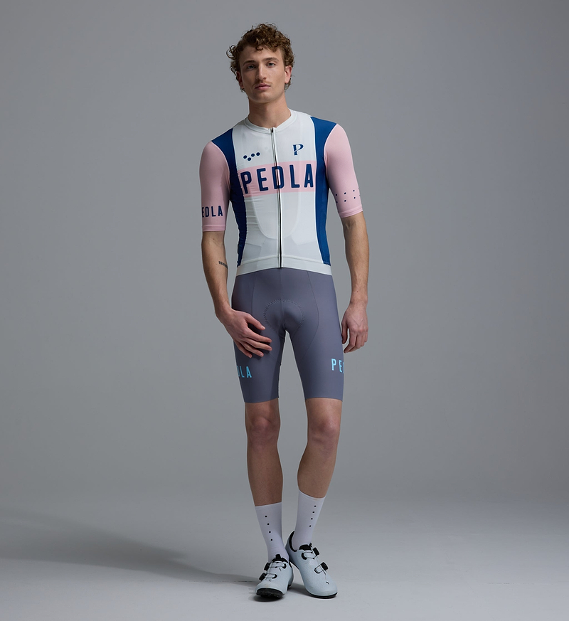 Men's Heritage Classic cycling jersey, vintage white with pink and blue accents, front view; breathable SPF50, moisture-wicking, four-way stretch, extended sleeves, low-cut collar, silicone hem gripper, PEDLA logo