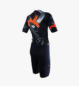 Close-up back view of Local Loops Pro Air Gravel one-piece cycling suit in black with orange logo — ultralight breathable high-stretch woven grid fabric, compressive bib, aerodynamic race fit, moisture-wicking quick-dry, integrated pockets, reflective accents for gravel and endurance riding