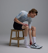 Close-side view of white Pedla lightweight cycling socks on cyclist, breathable moisture-wicking Coolmax nylon-Lycra blend for performance road cycling and hot-weather summer temperature control
