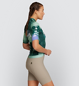 Side view of LOCAL LOOPS Women's Pro Pursuit 2.0 Cycling Jersey in Race Pine on model, showcasing the aerodynamic AeroPRISMA sleeves, heat-welded hems, and tailored fit for enhanced comfort, flexibility, and reduced drag during high-speed rides.