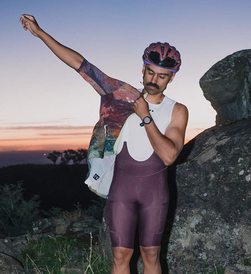 Pedla SuperSYSTEM men's fig/purple cycling bib shorts front view — compressive Superfit fabric, ultra-density EIT chamois, silicone leg grippers, hydration-ready rear pocket with hose channel and side stash pockets