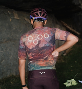 Men's ON_OFF GRID SuperSYSTEM cycling jersey (back view) — multicolor ultralight, high-stretch, moisture-wicking gravel/road jersey with bonded hem, ergonomic sleeves, rear pockets, hydration tube channel and reflective accents