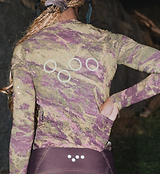 Close-up of ON_OFF GRID SuperSYSTEM women's long-sleeve cycling jersey in multi-rock camo - ultralight high-stretch breathable moisture-wicking fabric with bonded hem, reflective accents and hydration tube channel