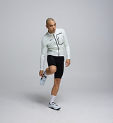 Side profile of the Men's Deflect 2.0 Cycling Jacket in Porcelain, showing flexible 4-way stretch side panels and underarms engineered for movement and comfort.