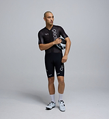 Front-facing image of a male cyclist wearing the Pro Pursuit Crit Suit in Black, highlighting the close-fitting aero cut, low-profile collar, and breathable woven fabric designed for speed.