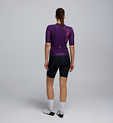 Rear image of the Plum Pursuit AIR Jersey worn by a cyclist, displaying three reinforced back pockets with elastic openings and reflective detailing for safety.