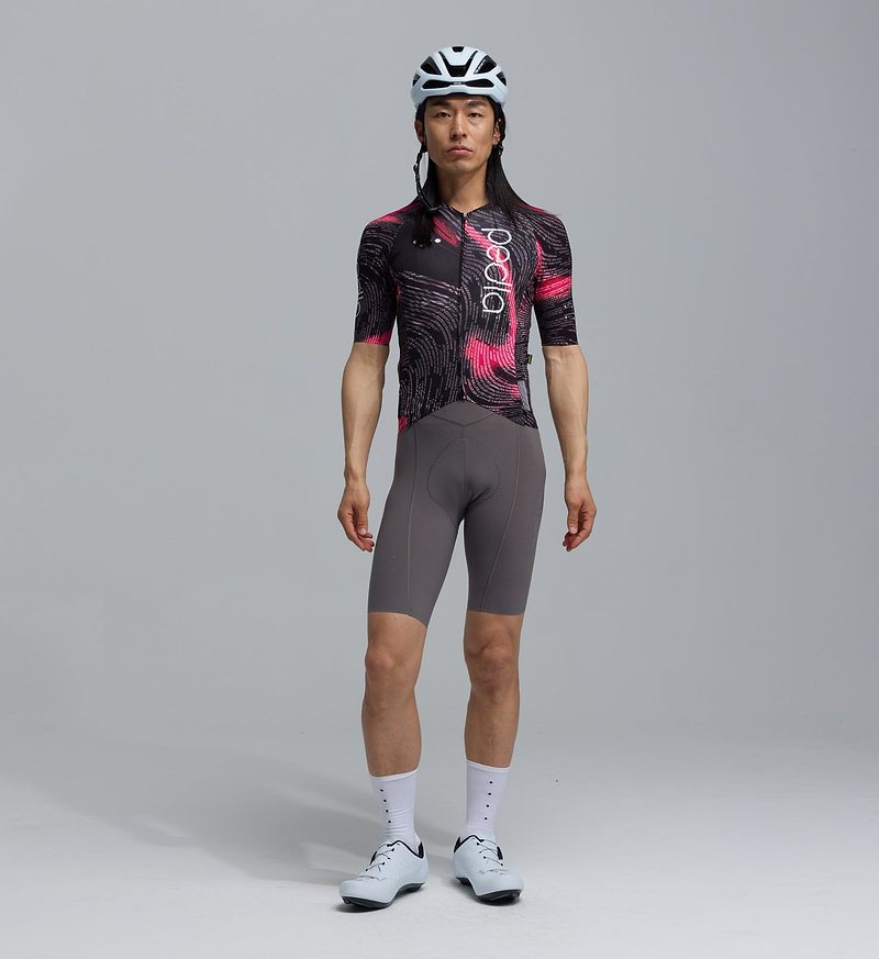 PRO Analogue Pro Pursuit 3.0 men's race-fit short-sleeve cycling jersey, black with pink data print, Italian aero fabric, aeroPRISMA heat-welded sleeves, mesh ventilation, reflective accents, 3 secure rear pockets