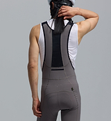Rear close-up of rider wearing PRO Analogue SuperFit Air men's battleship grey performance cycling bib tights — ultra-light Italian stretch-woven fabric, 4-way stretch compression, flatlock seams, ventilated perforated centre-back, Elastic Interface road chamois for 8+ hour endurance comfort, UPF 50+, iridescent reflective logos and small stash pocket