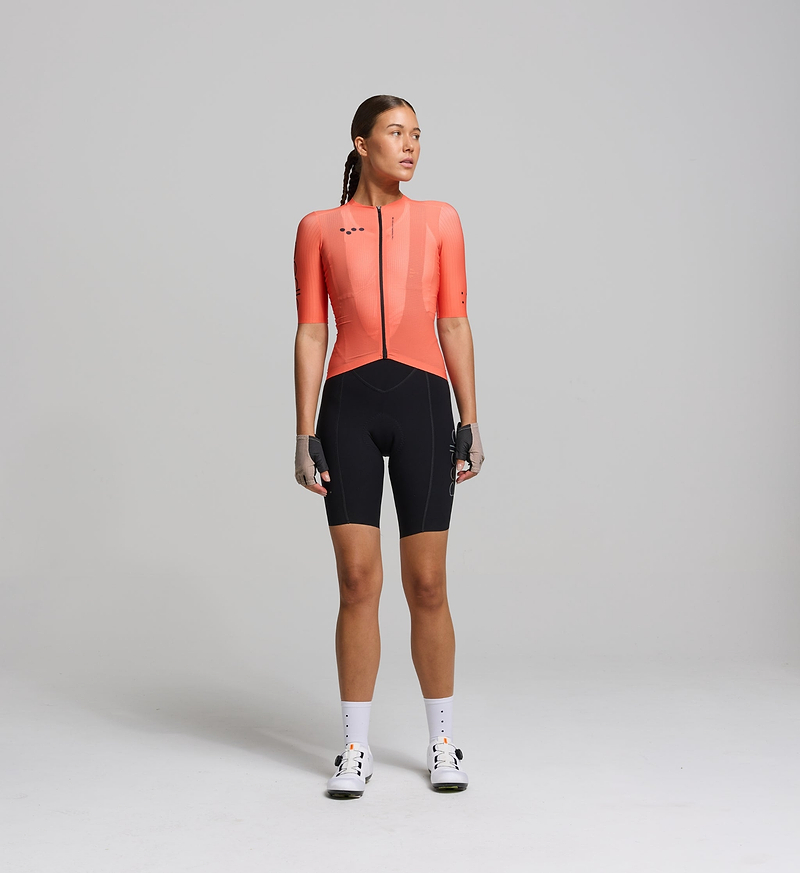 Cyclist wearing the Women’s Pursuit AIR Cycling Jersey in Apricot, showcasing its aerodynamic fit, advanced moisture-wicking fabric, and UPF 35+ sun protection for summer cycling.