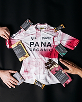 Pedla x Pana Organic white-and-pink team cycling jersey with limited-edition organic, plant-based vegan chocolate bars and crunchy hazelnut spread — sour cherry & Madagascan vanilla, pistachio, mint, spiced ginger, peanut caramel; artisanal cycling gift bundle, perfect gift for cyclists (total retail $280)
