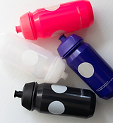 Four Pedla 500ml bidons in black, navy, olive, and sand; sustainable bottles with sleek design for modern cyclists