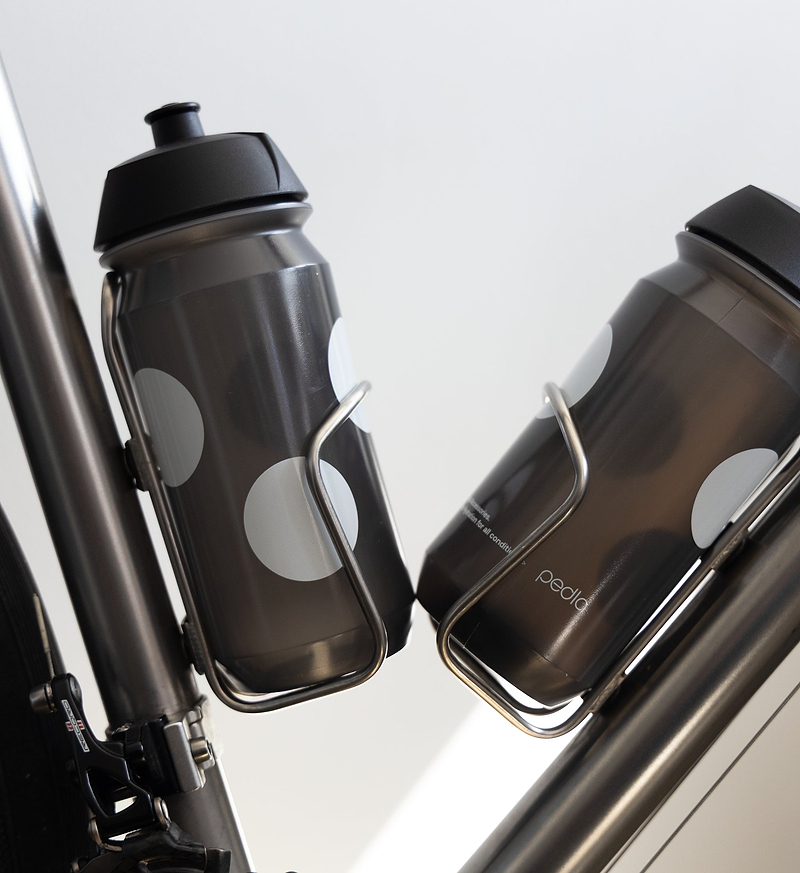 Pedla bidon securely mounted in bike bottle cage; compact, accessible, and perfect for hydration on the move