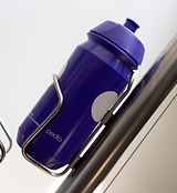 Purple Pedla bidon securely mounted in bike bottle cage; compact, accessible, and perfect for hydration on the move