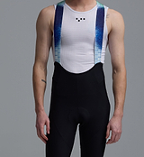 Race Division men's black training bib shorts close-up with blue bonded Grid Mesh braces, premium Italian compressive fabric, multi-density chamois (4+ hrs), race fit, laser-cut seamless cuffs with silicone grippers and reflective logos