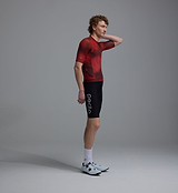 Side view Race Division men's deep-red grid training cycling jersey with breathable perforated panels, UPF 30+ sun protection, moisture-wicking four-way stretch REPREVE recycled polyester, silicone gripper hem, extended sleeves, low-cut collar