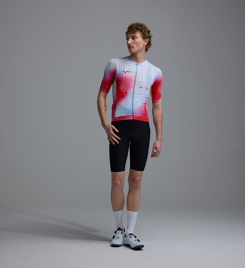 Men's Race Division red grid training cycling jersey front view — performance short-sleeve, UPF 30+, REPREVE recycled polyester blend, breathable perforated panels, silicone gripper hem, four-way stretch