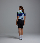 Race Division women's training cycling jersey back view — cobalt grid print, breathable REPREVE recycled polyester (83%)/elastane, UPF 30+, moisture-wicking, four-way stretch, silicone gripper hem, extended sleeves