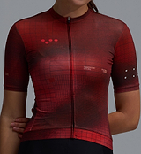 Close-up of women's deep red Race Division training cycling jersey with grid pattern, REPREVE recycled polyester, UPF 30+, moisture-wicking, breathable perforated panels, silicone gripper hem, front zip, four-way stretch