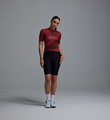 Women's Race Division short-sleeve training cycling jersey, deep red grid front, UPF 30+, 83% REPREVE recycled polyester/17% elastane, breathable perforated panels, silicone gripper hem, moisture-wicking microfiber, four-way stretch