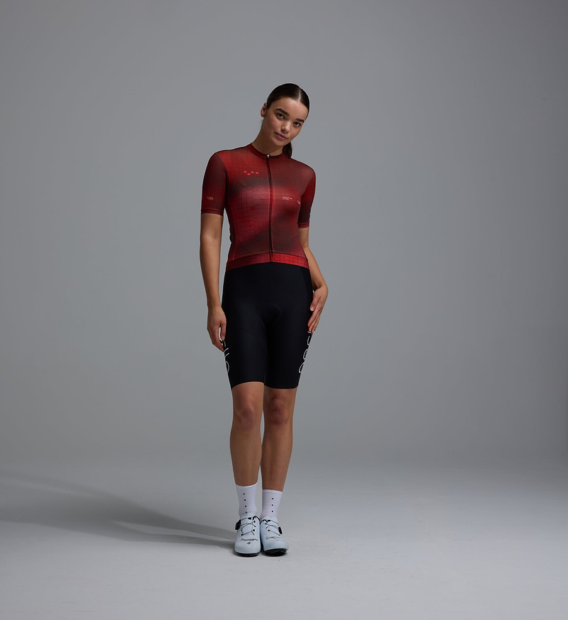 Women's Race Division short-sleeve training cycling jersey, deep red grid front, UPF 30+, 83% REPREVE recycled polyester/17% elastane, breathable perforated panels, silicone gripper hem, moisture-wicking microfiber, four-way stretch