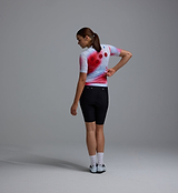 Race Division women's training jersey, red grid back, UPF 30+ sun protection, breathable perforated panels, REPREVE recycled polyester, four-way stretch, silicone gripper hem — all-season road cycling top