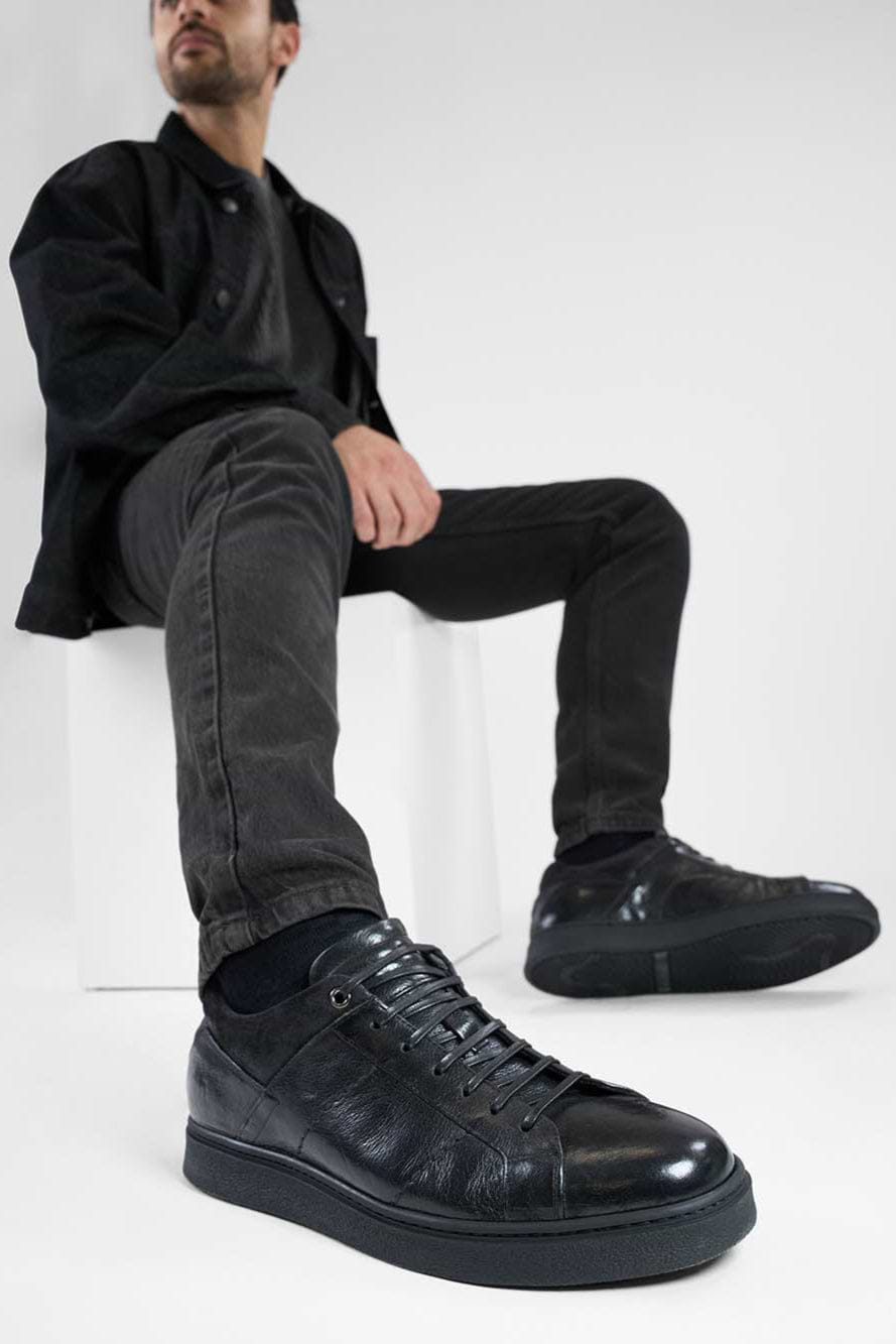 CREED jet-black distressed sneakers.