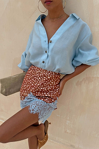 Fawn Mini Maeva Skirt in brown animal print with blue lace trim, styled with a light blue button-up shirt.