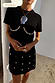 Black Crochet Shell Wrap Skirt with gold shell details and matching t-shirt, styled for a premium vacation look.