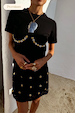 Black Crochet Shell Wrap Skirt with gold shell details and matching t-shirt, styled for a premium vacation look.