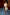 Thumbnail for Gold vegan leather mini wrap skirt worn with a gold sleeveless top and blue heels against a wood-panelled wall.