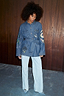 Blue Denim Manifestation Jacket featuring a tie waist and tarot motifs, paired with light-wash jeans.