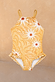 Girl's Yellow Sun Swimsuit featuring a sun print, thin straps and frill detailing against a neutral wall.