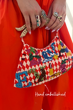 Red check Cirque Bag with hand-beaded motifs and a wooden handle, highlighting the hand-embellished glass bead details.