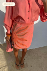 Pink Sol Beaded Wrap Skirt featuring hand-embroidered sun details, styled as a vacation co-ord on the beach.