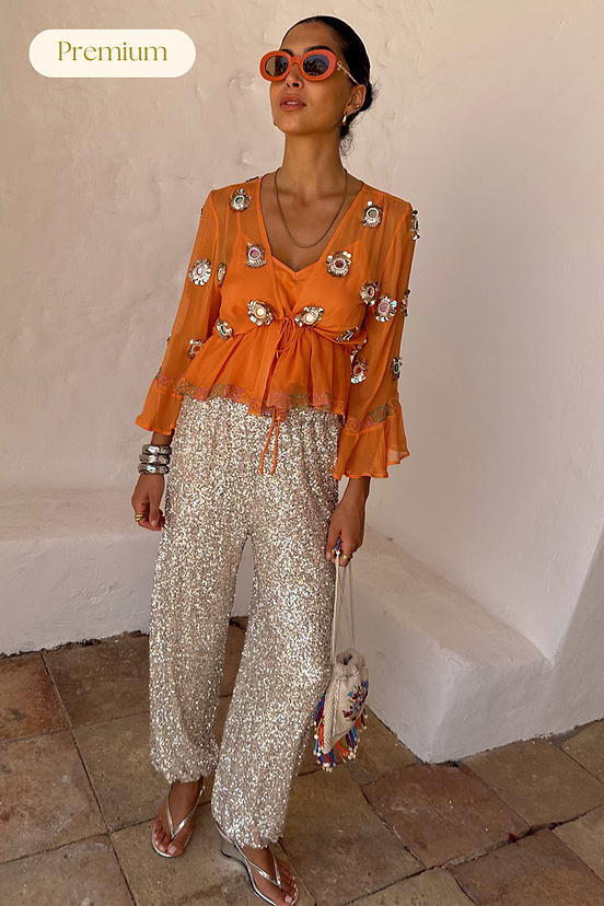 Apricot Embellished Top in orange with mirror embroidery and tie waist, styled with silver sequin Naomi trousers.