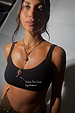 Deloris Thin Chain Key Necklace with a brass key charm and red gemstone, worn by a model.