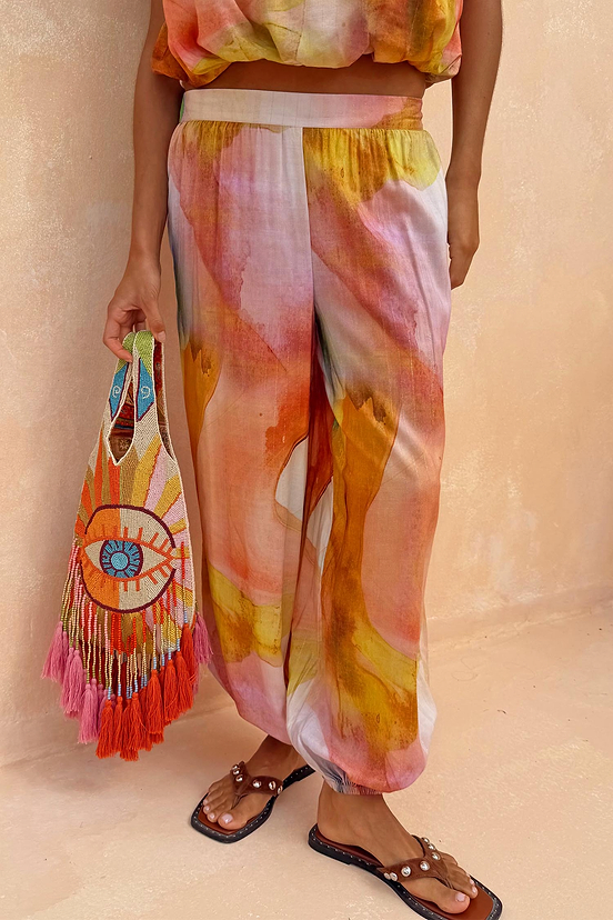 Abstract Balloon Trousers in a pink and ochre sunset wash print with a loose silhouette and cuffed ankles.