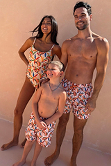 Men’s Banana Swim Shorts in a multi-coloured recycled fabric, shown as part of a matching family vacation set.