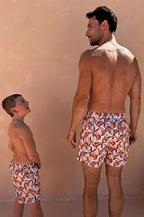 Men's Banana Swim Shorts featuring a multi-coloured print on cream, shown with matching boys' shorts for vacation.