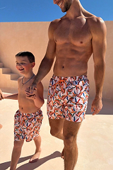 Men's Banana Swim Shorts featuring a multi-coloured print, styled for a matching family vacation look.