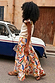 Banana Saige Skirt in a multicolour banana print with cotton tiered panels and a frill hem in a street setting.