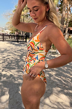 Banana Scoop Swimsuit in cream featuring colourful banana motifs and side tie detailing on a model.