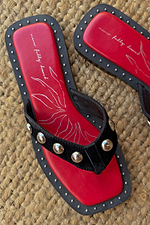 Black Leather Stud Sandals with silver studs, a square toe and a red graphic footbed on a woven mat.