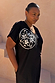 Multi-wear Black Dolce Vita T-Shirt Dress with a white sun motif and tee neckline, shown on a size XL model.