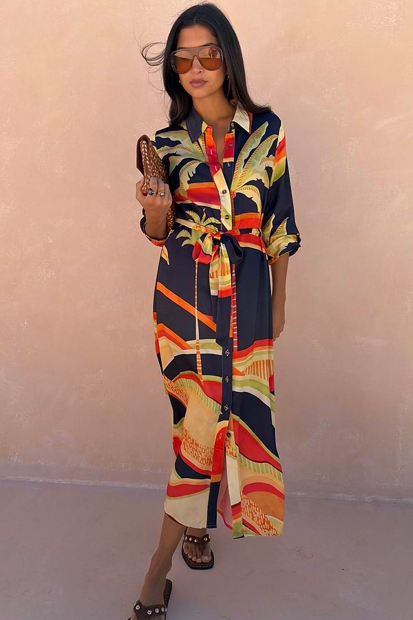 Blue Palm Shirt Dress featuring vibrant orange and yellow palm motifs, a button-up front and adjustable tie-waist.