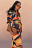 Blue Palm Shirt Dress featuring vibrant palm motifs and a tie waist, paired with an animal print clutch.