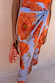 Blue Poppy Jaspre Skirt featuring large orange flowers on a light blue base with an iconic wrap tie fastening.